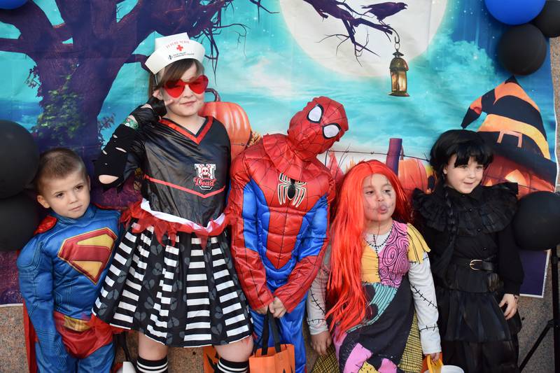 A group of kids poses for a picture in their costumes during Rock Falls’ Biz Boo! trick or treating event Friday, Oct. 24, 2025. Costumed kids flooded the downtown, going door to door for treats.