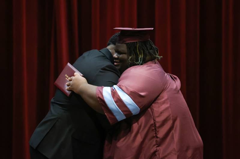 Kankakee High School graduate Christian Lyles shares a hug with Principal Albert Brass, left, after receiving his diploma during the summer commencement ceremony at the high school on Tuesday, July 29, 2025.