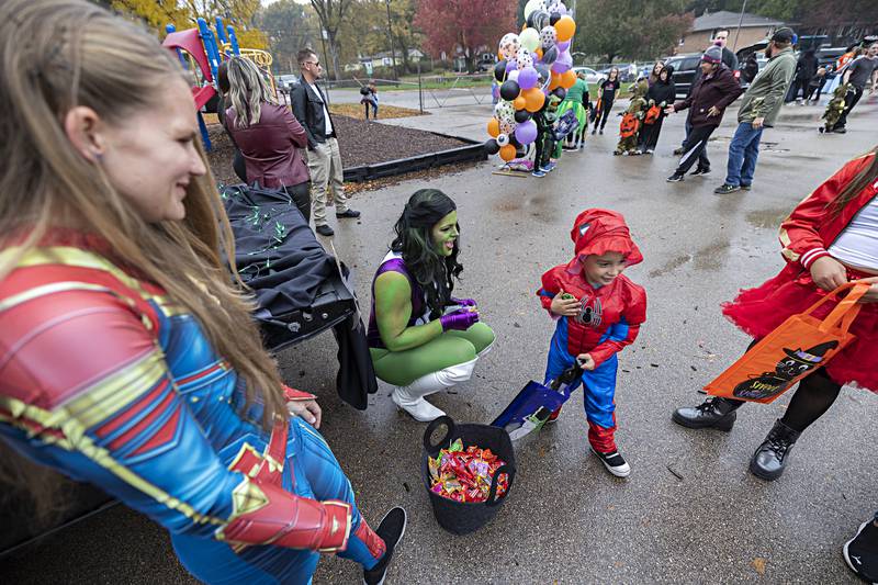 Dressed as She-Hulk, Claudia Grenlund hands candy to Landon Danielowski, 4, Wednesday, Oct. 25, 2023 at Washington School in Dixon. Samantha Kingsbury (left) and Grenlund were representing Sauk Valley College’s Police Academy.