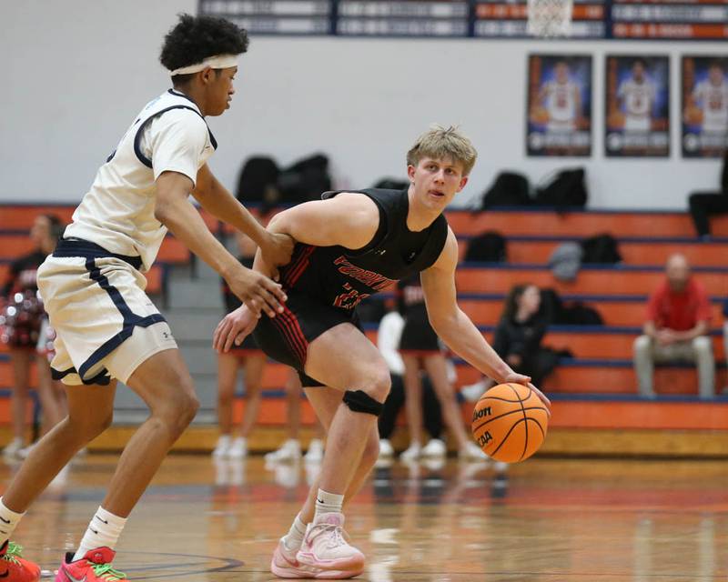Yorkville's Frankie Pavlik (21) handles the ball against the defense of Downers Grove South's Adam Flowers (3) during their Class 4A Naperville North Regional final basketball game between Yorkville at Downers Grove South, Feb 27, 2026 in Naperville.