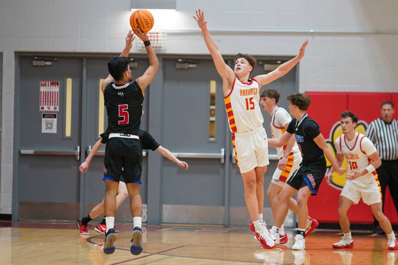 Batavia’s Dane Farrar (15) defends against a three-point shoot from Marmion's Ali Muhammed Tharwani (5) during a game at Batavia High School on Wednesday, Nov. 26, 2025.