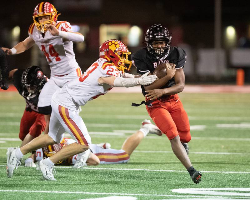 Glenbard East's Kedrick Dennis carries the ball as Batavia's Andrew Culotta makes the tackle at the Class 7 A Second Round playoff game on Friday, Nov. 7,2025 in Lombard.