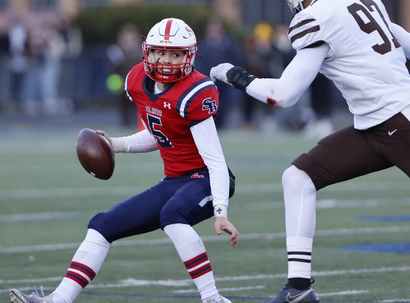 Mt. Carmel's Joey Quinn (97) closes in on St. Rita quarterback Steven Armbruster (5) during the class 7A semi-final playoff game between Mt. Carmel and St. Rita high schools on Saturday, Nov. 23, 2024 in Chicago.
