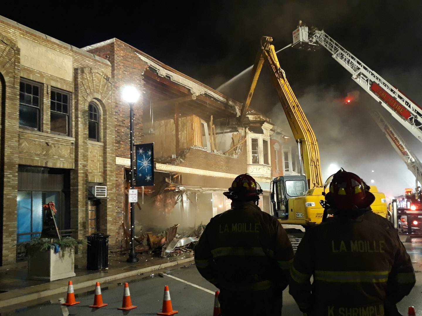 The former Meyer's Furniture building is demolished Friday, Dec. 30, 2022, in an effort to contain the fire on the 700 block of Illinois Avenue in downtown Mendota.