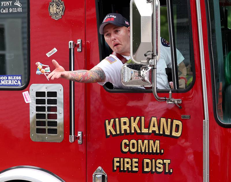 A member of the Kirkland Fire Department throws out and as they head down Main Street Friday, July 4, 2025, during the Fourth of July parade in downtown Kirkland.