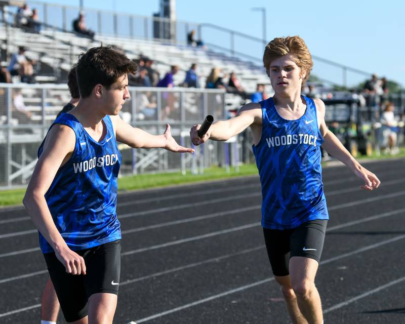 Ellery Shutt, right, of Woodstock High School hands the baton off to teammate Milo McLeer during the 800-meter relay during the Kishwaukee River Conference track meet held at Plano High School on Tuesday May 7, 2024.