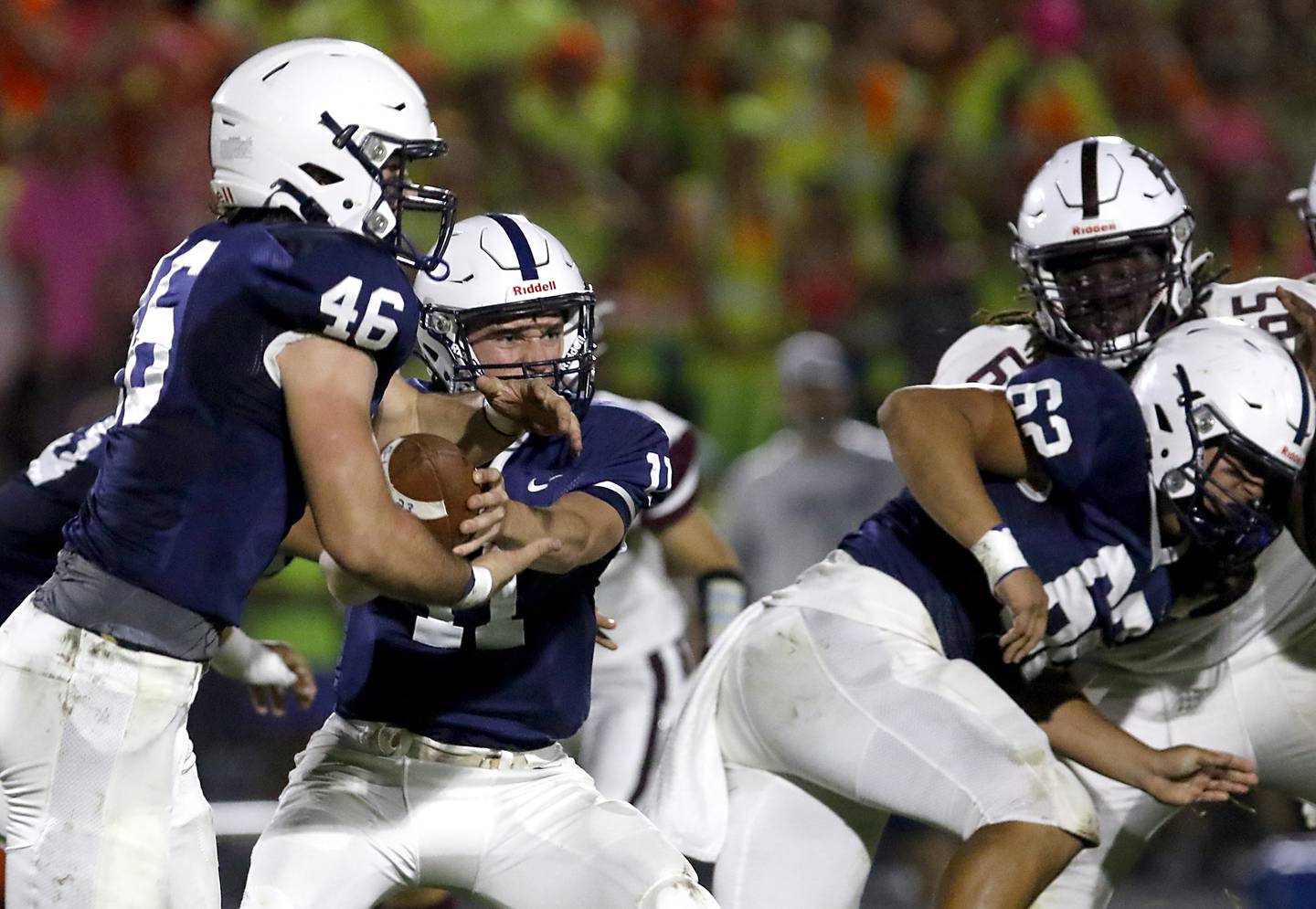 Cary-Grove's Peyton Seaburg hands the ball off to Logan Abrams during a Fox Valley Conference football game against Prairie Ridge on Friday, Sept. 22, 2023, at Cary-Grove High School in Cary.