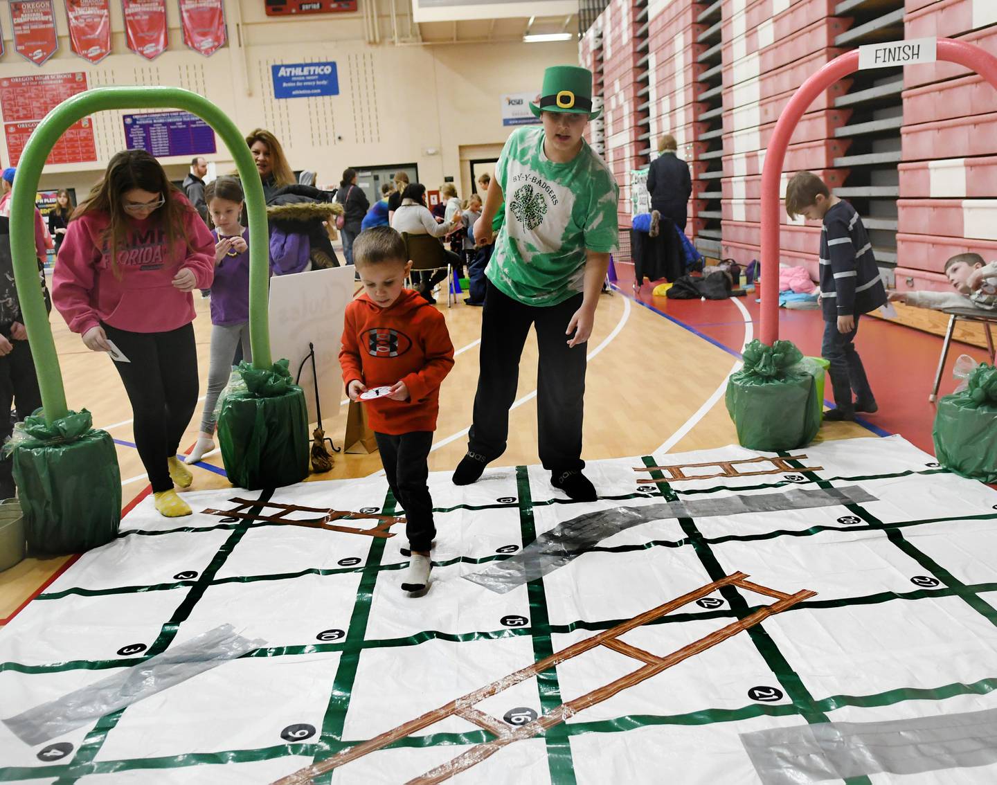 Andrew Hickman a member of the BY Badgers 4-H Club helps direct Isacc Blankenship, 4, of Stillman Valley through the club's 'Chutes and Ladders' game at the 4-H Penny Carnival on Saturday, March 18.
