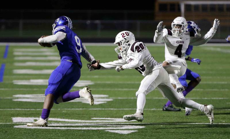 Larkin's Jalen Miller (9) slips around Elgin’s Joshua Ninan (20) to head upfield for a touchdown during the annual crosstown rival game at Memorial Field  Friday October 14, 2022 in Elgin.