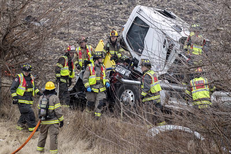 Firefighters work to free the driver of a semi that left the roadway on Interstate 88 on Monday, Feb. 3, 2025, between Dixon and Rock Falls.