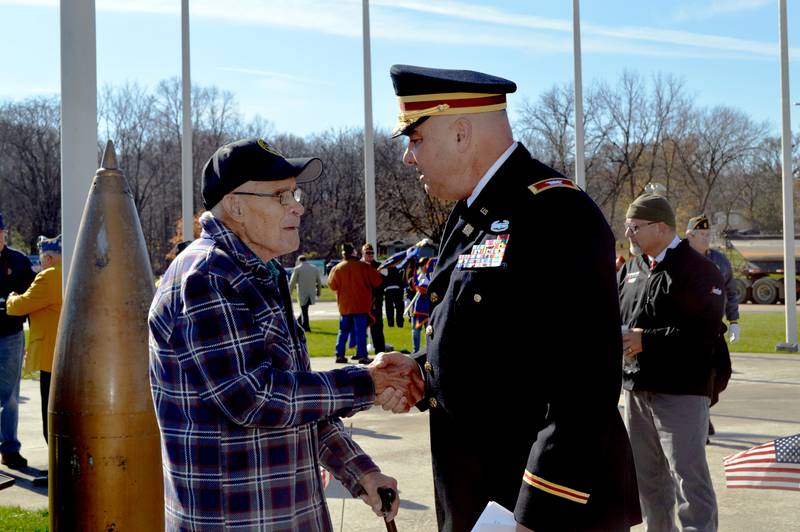 Retired U.S. Army Col. Jerry Newman (right) shakes hands with retired U.S. Army Cpl. Wilbur Maves, of Dixon, on Monday, Nov. 11, 2024, after the conclusion of a Veterans Day ceremony at Dixon's Veterans Memorial Park.