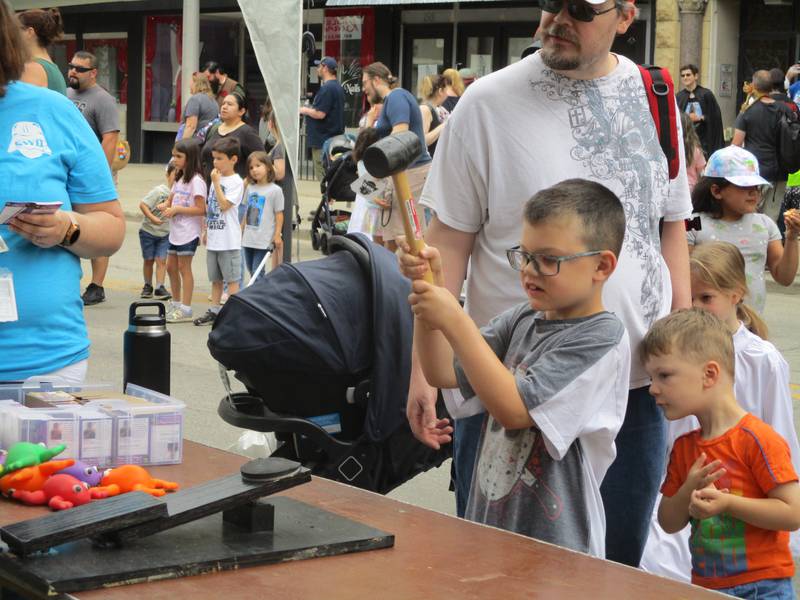 Jackson Alexander plays Feed the Jabba, one of the kids games on Chicago Street during Star Wars Day in Joliet, as his father, Dan Alexander, watches on June 4, 2022.