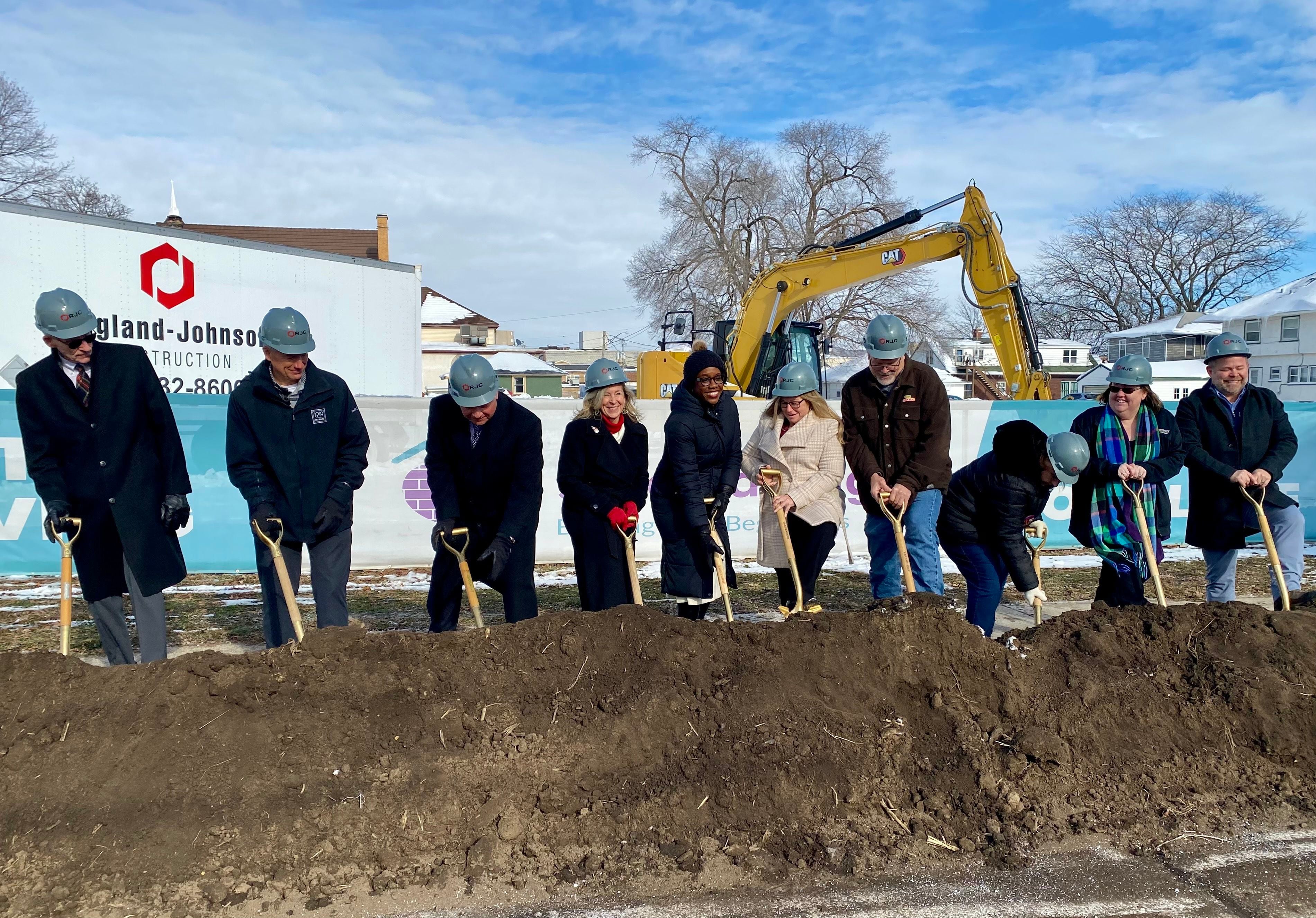 DeKalb area officials including elected leaders, staff and supporters of Safe Passage Inc., pose for a group photo on Friday, Dec. 5, 2025, at the agency's ceremonial groundbreaking to mark the start of construction on a new domestic violence survivor shelter at 217 Franklin St., in DeKalb.