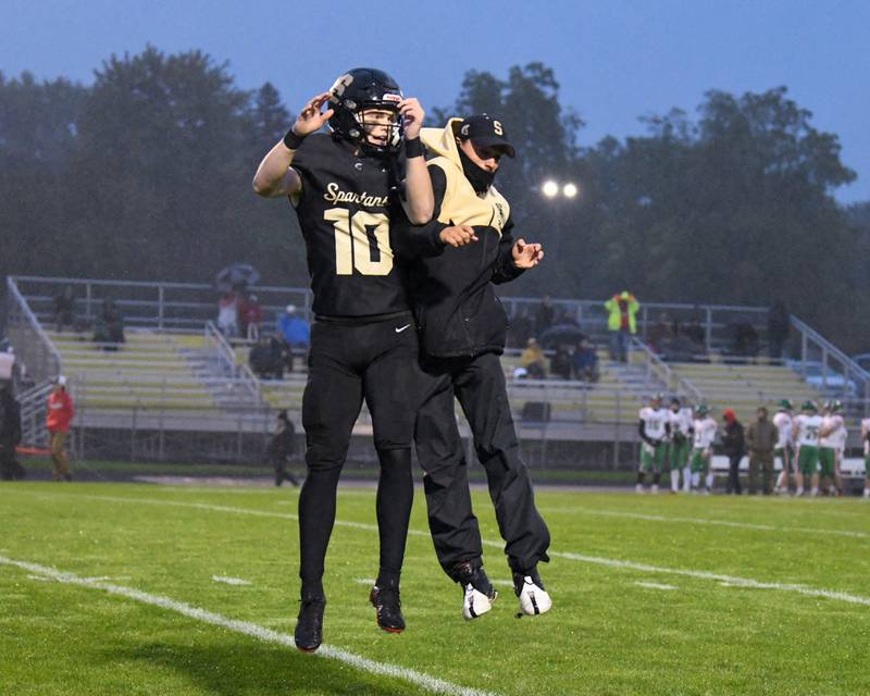 Sycamore Burke Gautcher (10) celebrates with his coach Luke Ryan in the first quarter on Friday Oct. 10, 2023, after scoring a touchdown against Lasalle-Peru in Sycamore.
