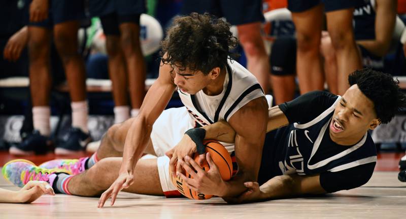Benet Academy's Blake Fagbemi, left, and Evanston's Kaidan Chatham go to the floor for a loose ball during the IHSA Class 4A boys basketball state semifinals at State Farm Center on Friday, March 14, 2025 in Champaign.
