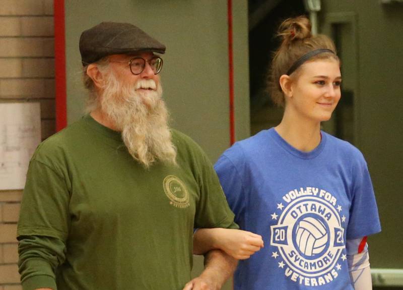 Air Force Veteran Patrick Denny is escorted by his niece Lauren during the Volley for Vets presentation before the volleyball game against Sycamore on Thursday, Oct. 12, 2023 at Kingman Gym.