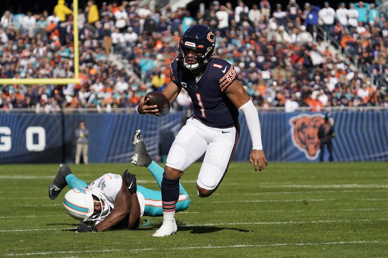 Chicago Bears quarterback Justin Fields runs for yardage while avoiding a tackle by Miami Dolphins linebacker Channing Tindall during the first half, Sunday, Nov. 6, 2022 in Chicago.