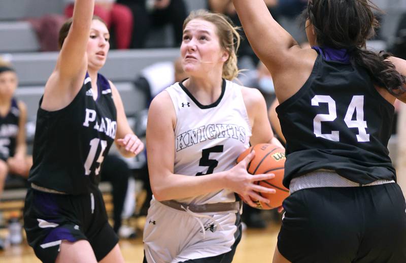 Kaneland’s Brigid Gannon goes to the basket between Plano’s Alex Bishop and Mikayla Walls during their game Tuesday, Dec. 13, 2022, at Kaneland High School in Maple Park.