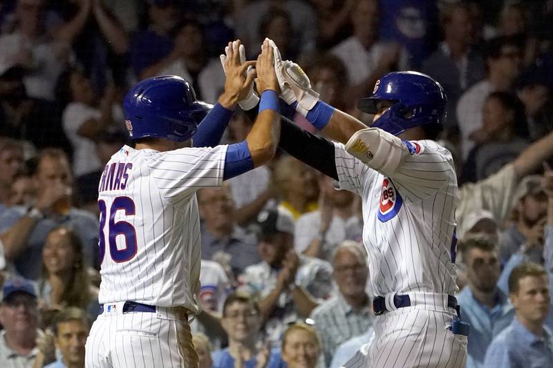 Chicago Cubs' Alfonso Rivas, left, greets Seiya Suzuki after they scored on Suzuki's two-run home run off Cincinnati Reds starting pitcher Justin Dunn during the fifth inning of a baseball game Tuesday, Sept. 6, 2022, in Chicago. (AP Photo/Charles Rex Arbogast)
