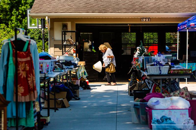 A shopper looks over items for sale during Westmont’s weekend garage sales, Sunday, August 4, 2024.