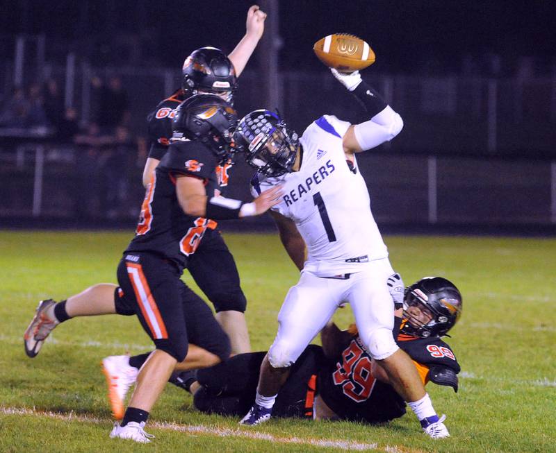 Plano quarterback Armando Martinez (1) avoids a sack by tossing the ball before three Sandwich defenders sack him during a varsity football game at Sandwich High School on Friday, Sept. 8, 2023.