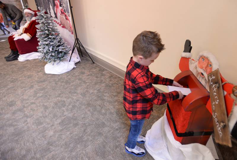 Oliver Zimmer of Downers Grove puts his letter to Santa inside the mailbox during the Downers Grove Park District's Candy Cane Lane event Saturday, Dec. 2, 2023.