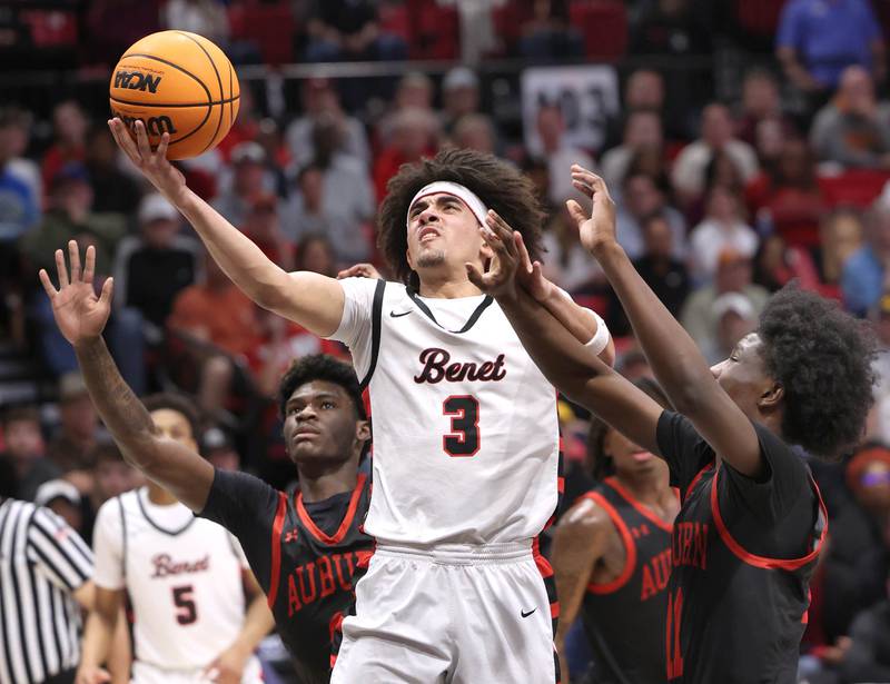 Benet's Jayden Wright gets to the basket between two Auburn defenders Monday, March 9, 2026, during their IHSA Class 4A supersectional matchup in the Convocation Center at Northern Illinois University in DeKalb.