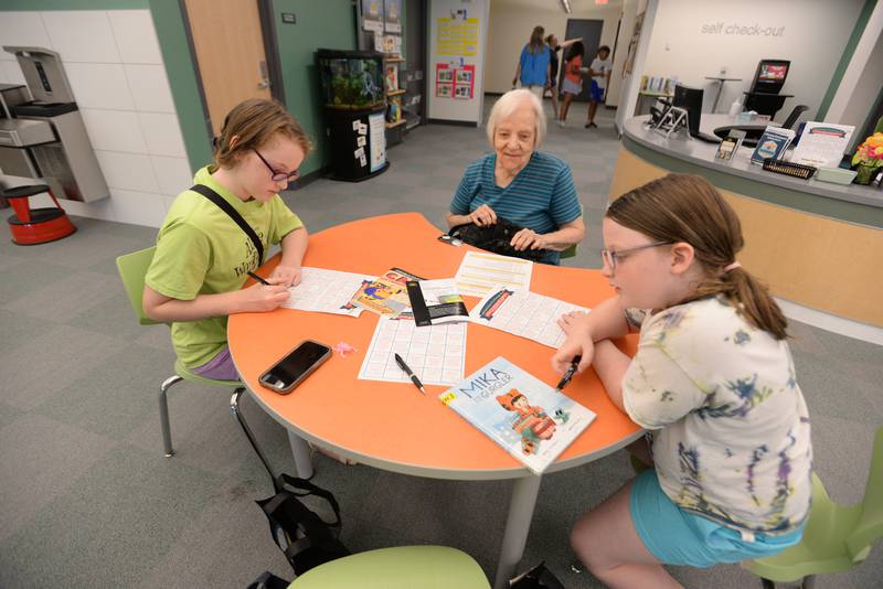 People including (left to right) Lucie Mueller, Nancy Thomas and Paige Mueller of La Grange Park participate in a scavenger hunt during the La Grange Park Library Grand Reopening Saturday Aug 3, 2024.