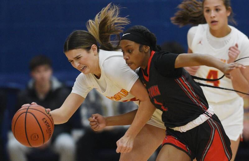 Batavia’s Brooke Carlson, left, draws contact from Alton’s Justice Hayes during the championship game of the Morton College basketball tournament Saturday December 30, 2023 in Cicero.