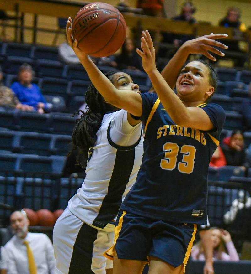 Sterling’s Joslynn James is fouled by Davenport North’s Journey Houston during the IHMVCU Shootout at the Carver Center in Rock Island