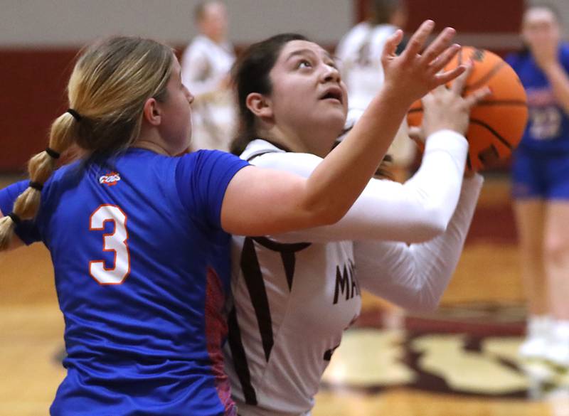 Marengo's Ariana Rodriguez shoots the ball in front of Genoa-Kingston's Madelynn Swanson during an IHSA Class 2A Marengo Regional semifinal girls basketball game on Monday, Feb. 16, 2026, at Maraengo High School.