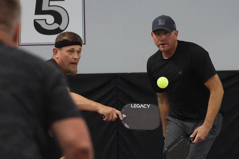 Kyle Brandenburg stands back as Adam Nurczvk returns the ball the ball in a pickleball league match at GameChangers on Tuesday, May 28, 2024 in Shorewood.