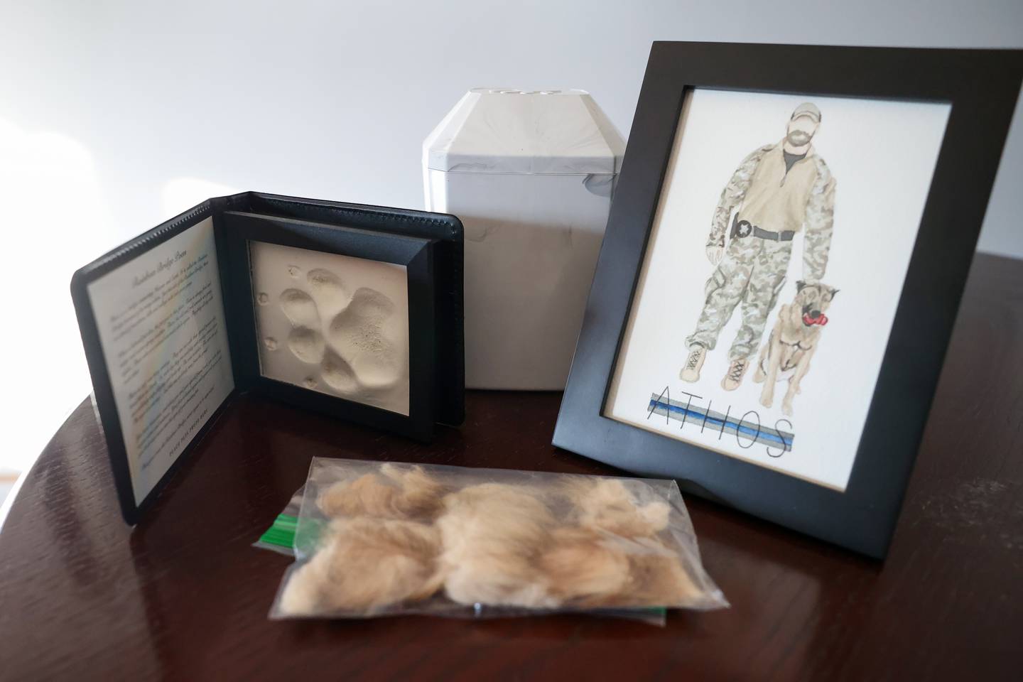 Keepsakes, including a paw print, fur clippings and a watercolor painting, accompany the ashes of Bourbonnais Police Sgt. Dave Herberger's K-9 partner Athos, who suddenly fell ill and died on Jan. 13.