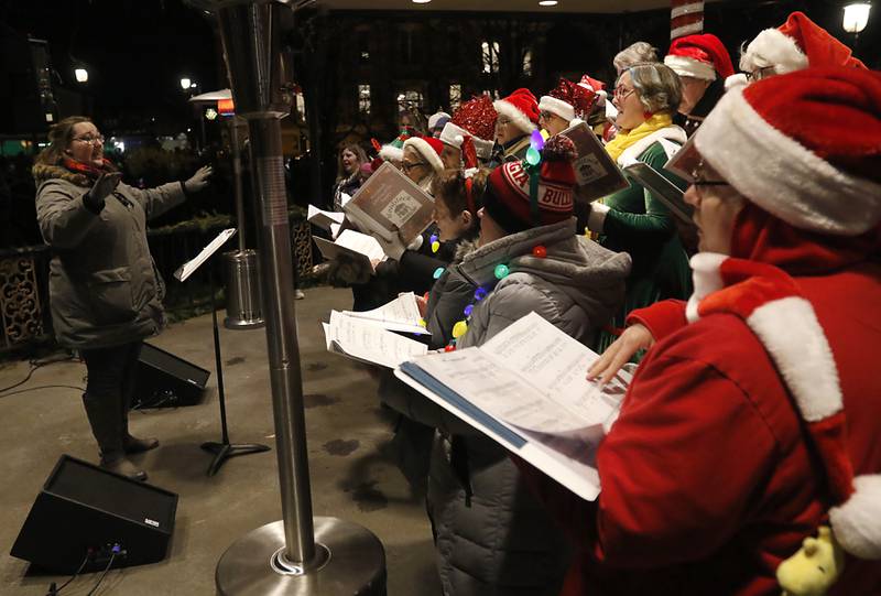 Members of the Woodstock Community Choir sign Christmas carols during the Lighting of the Square Friday, Nov. 24, 2023, in Woodstock. The annual holiday season event featured brass music, caroling, free doughnuts and cider, food trucks, festive selfie stations and shopping.