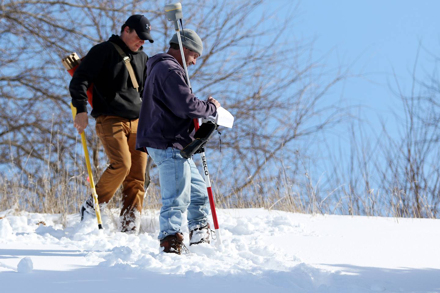 Rodney Miller, front, and Brad Judson with Vanderstappen Surveying, take measurements on an elevated plot of land for sale where 288 apartment units are proposed near the intersection of N. Richmond Road and Blake Blvd on Monday, Feb. 1, 2021, in McHenry.