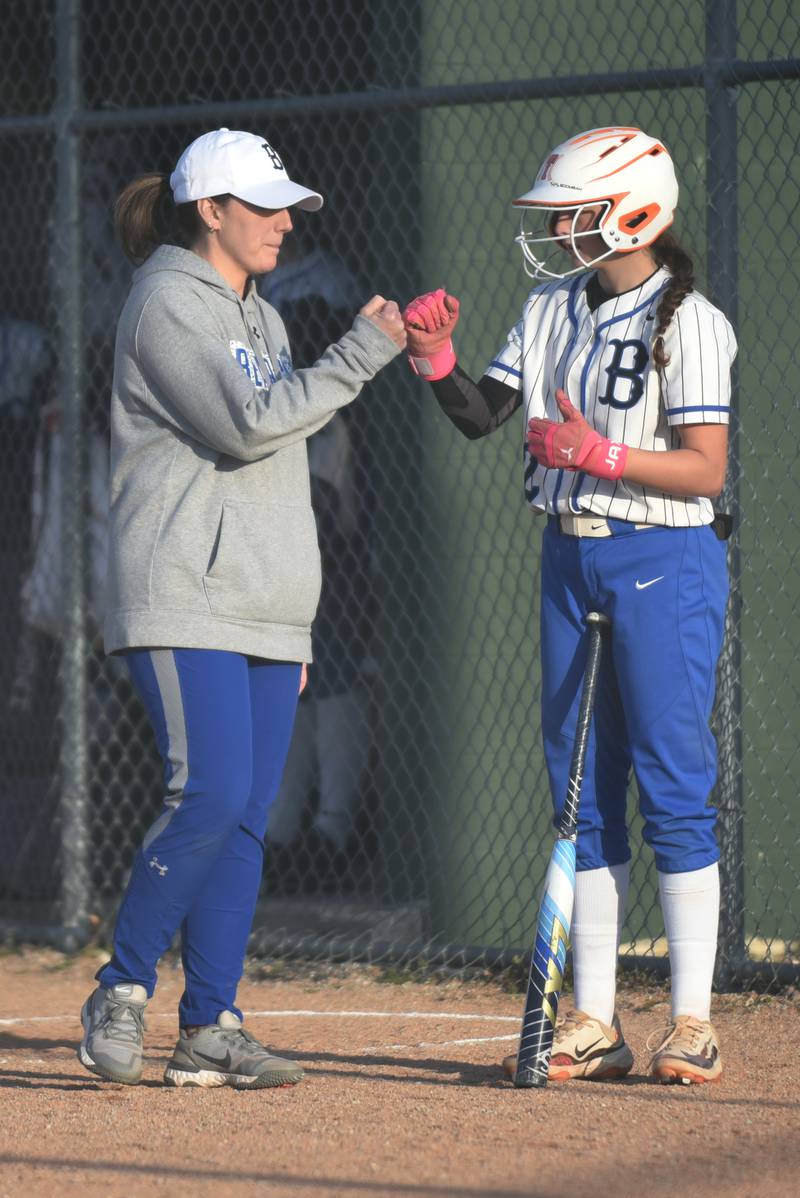 Milford-Cissna Park softball coach Alyse Morefield, left, gives knucks to Jossalin Lavicka before Lavicka's at-bat during a home game against Oakwood Wednesday, April 16, 2025.