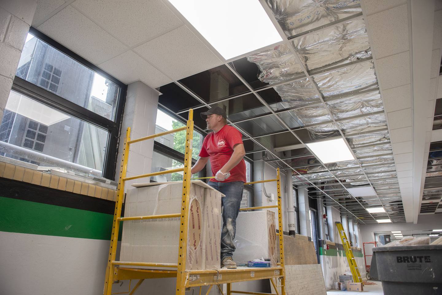 Kenny Wolf of Gehrke Construction works on the ceiling tiles Wednesday, July 27, 2022 in Rock Falls High School’s renovated cafeteria. The kitchen and dining area has undergone extensive updating.