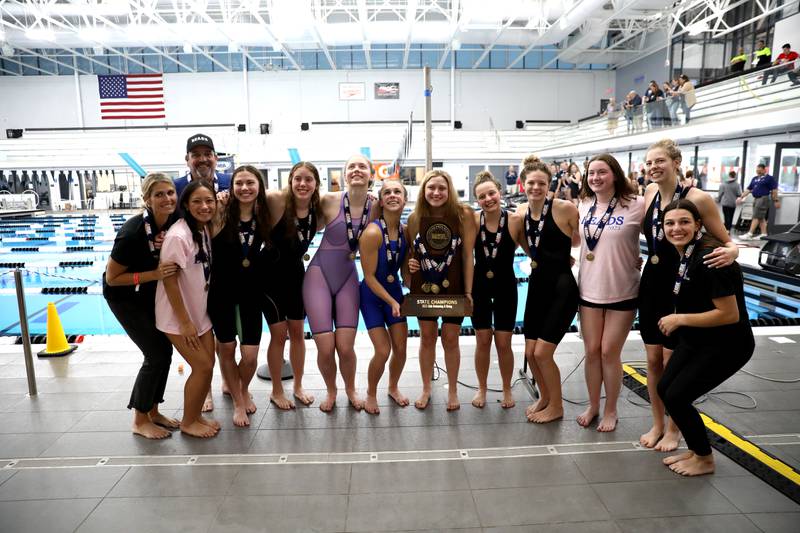 Rosary swimmers celebrate their first place state trophy in the IHSA Girls State Swimming and Diving Championships at the FMC Natatorium in Westmont on Saturday, Nov. 11, 2023.