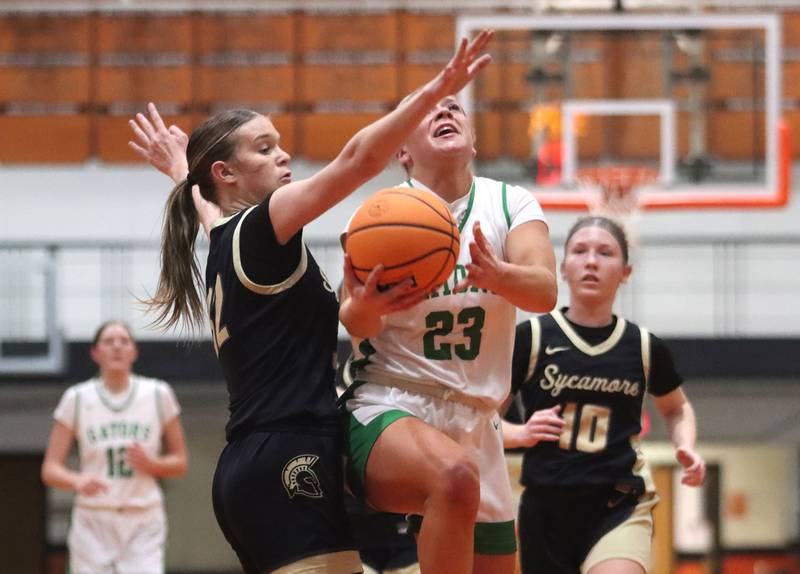 Crystal Lake South’s Laken LePage, center, works past Sycamore’s Quinn Carrier in girls IHSA Class 3A Sectional basketball on Tuesday, Feb. 24, 2026, at Crystal Lake Central High School in Crystal Lake.