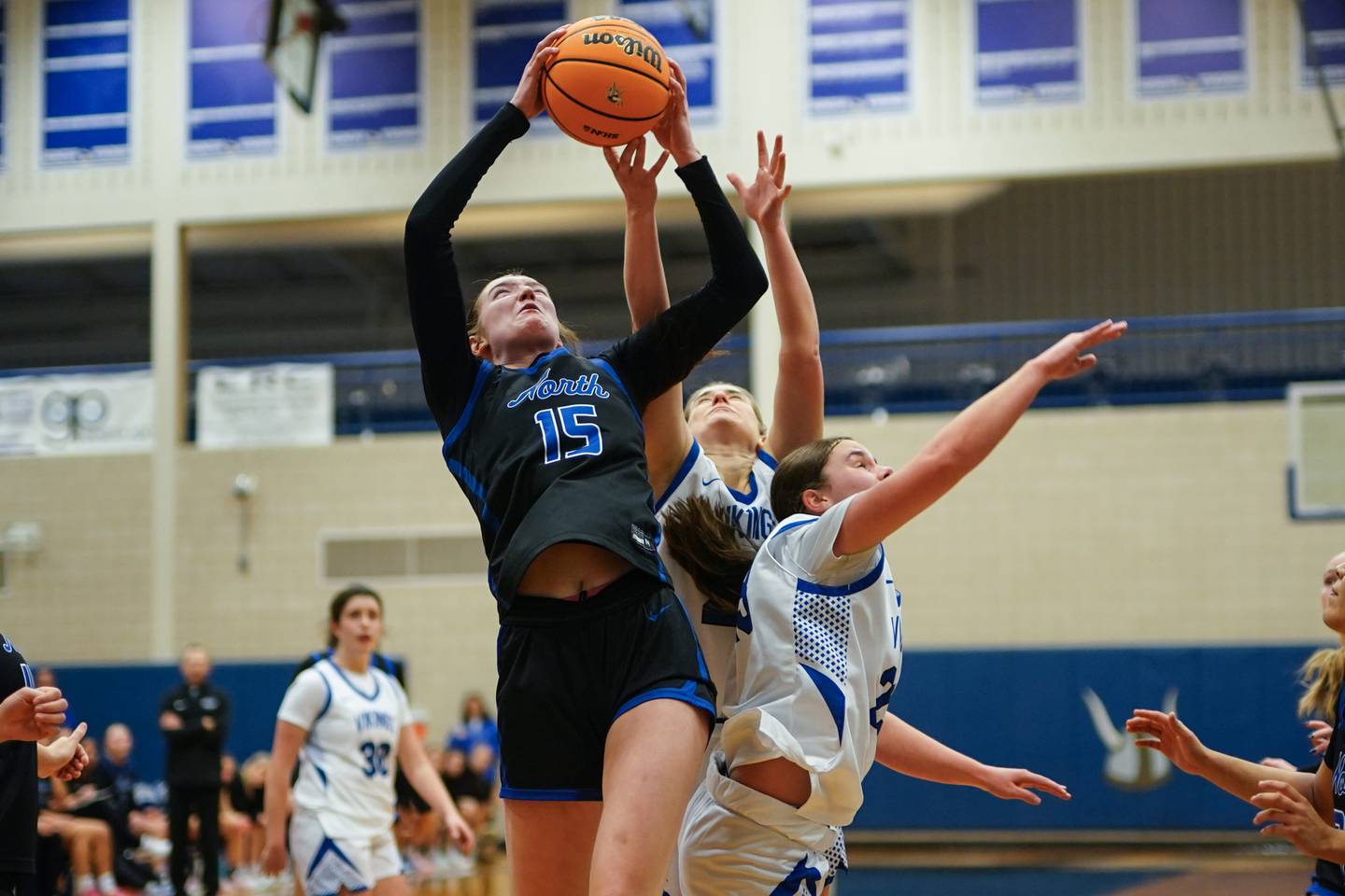 St. Charles North's Bronwyn How (15) pulls down a rebound against Geneva during a game at Geneva High School on Thursday, Dec. 4, 2025.