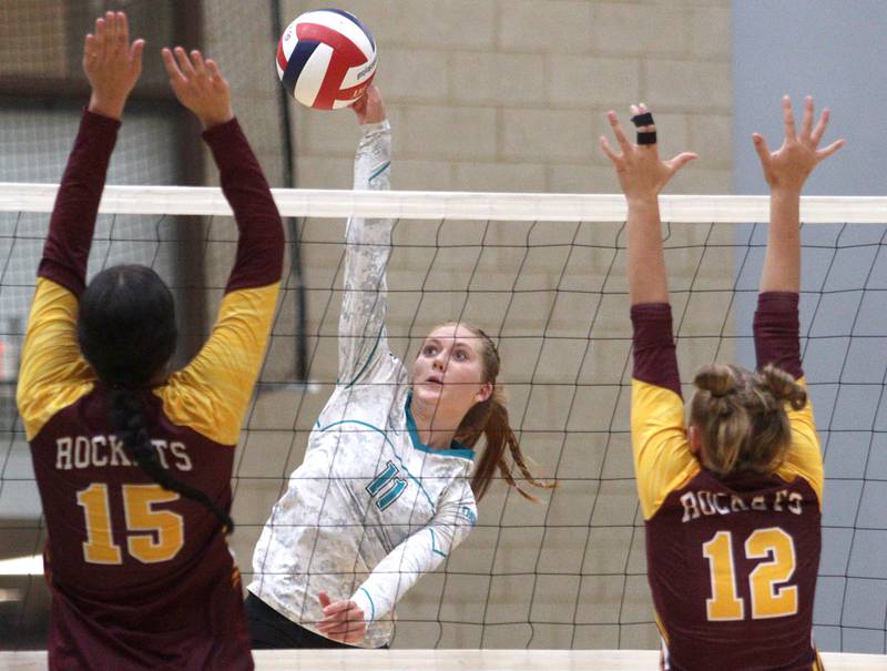 Woodstock North’s Alexis Hansen, center, sends the ball over the net against Richmond-Burton in varsity volleyball at Woodstock Monday night.