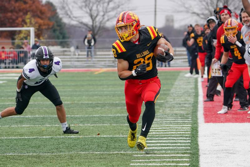 Batavia’s Nathan Whitwell (28) carries the ball against Downers Grove North's Caden Chiarelli (4) during a class 7A quarterfinal playoff football game at Batavia High School on Saturday, Nov. 16, 2024.