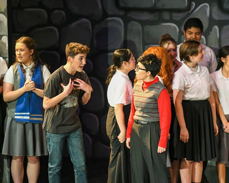Downers Grove North’s Quinn McCloud who plays Wayne talks to Eva Lilly Pokay who plays Harry during the production of Puffs on Saturday Nov. 23, 2024, held at Downers Grove North High School.