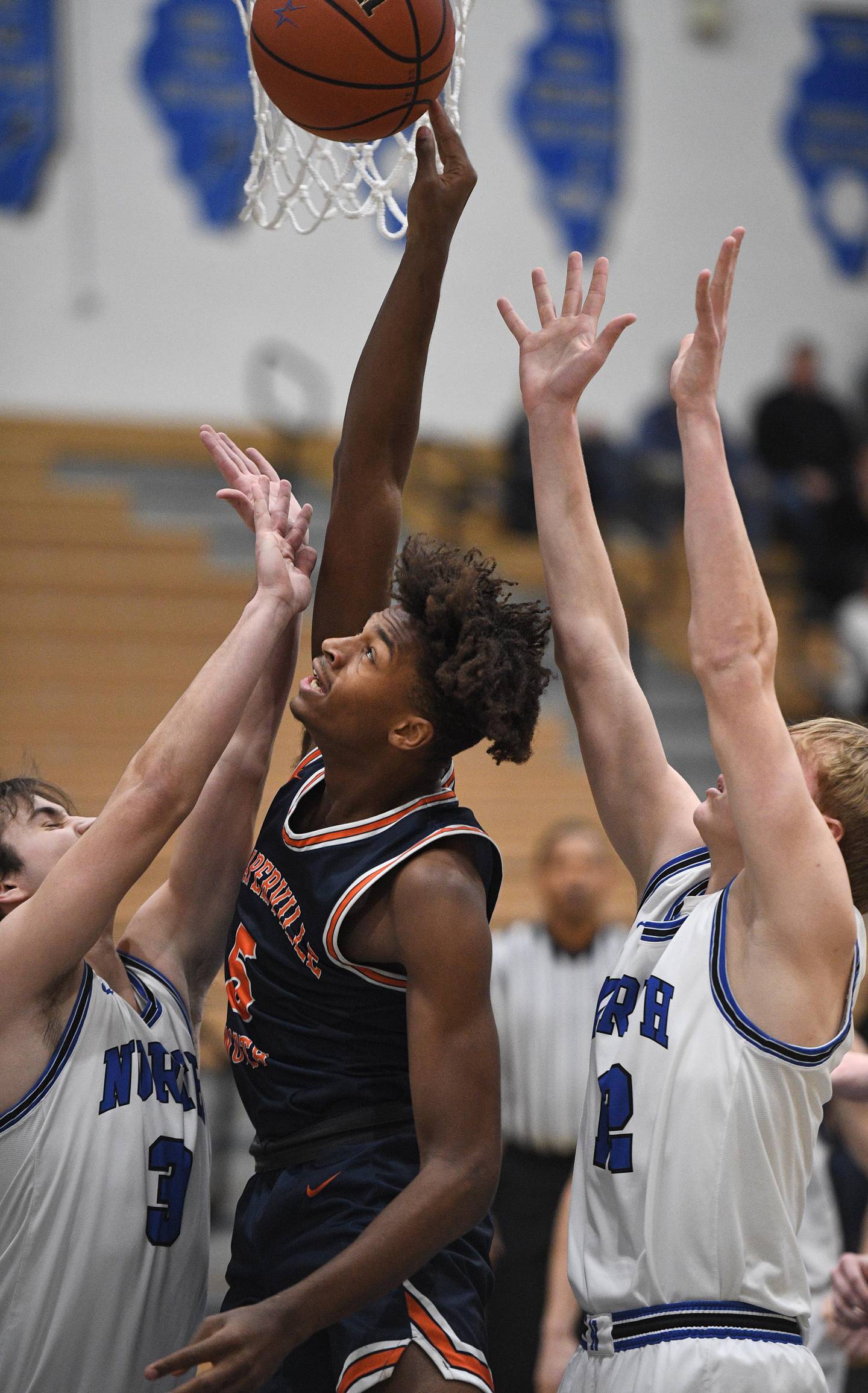 St. Charles North’s Cameron Ring and Parker Reinke, right, sandwich Naperville North’s Luke Williams as he tries to shoot in a boys basketball game in St. Charles on Wednesday, January 18, 2023.