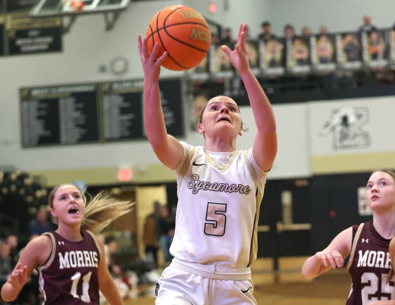 Sycamore's Grace Amptmann gets a layup in front of two Morris defenders during their game Tuesday, Jan. 13, 2026, at Sycamore High School.