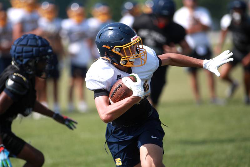 Sterling’s Koltyn Chapman carries the ball during a joint practice with Glenbard South and Oswego East football teams on Tuesday, July 15, 2025 in Oswego.
