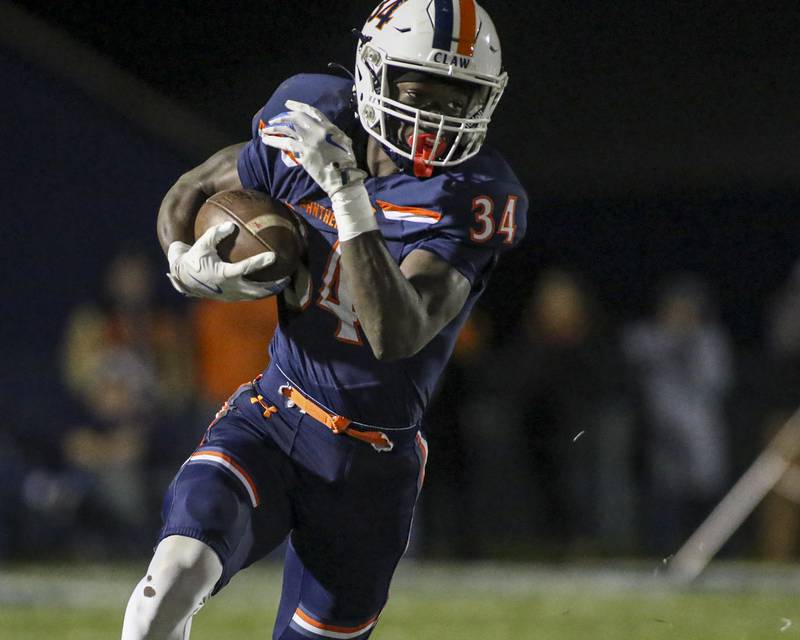 Oswego's Ammar Banire (34) takes off around the right end during Class 8A semifinal football game between Lockport at Oswego. Saturday, Nov 22, 2025 in Oswego.
