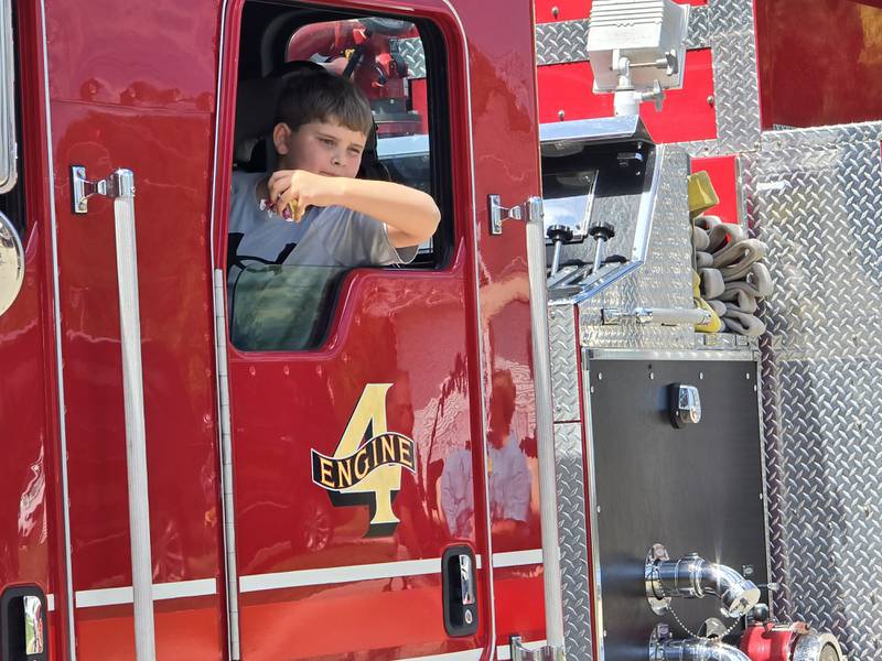 A boy throws candy from one of the Wenona Fire Protection District engines Sunday, Aug. 11, 2024, during the Wenona Days Grand Parade.