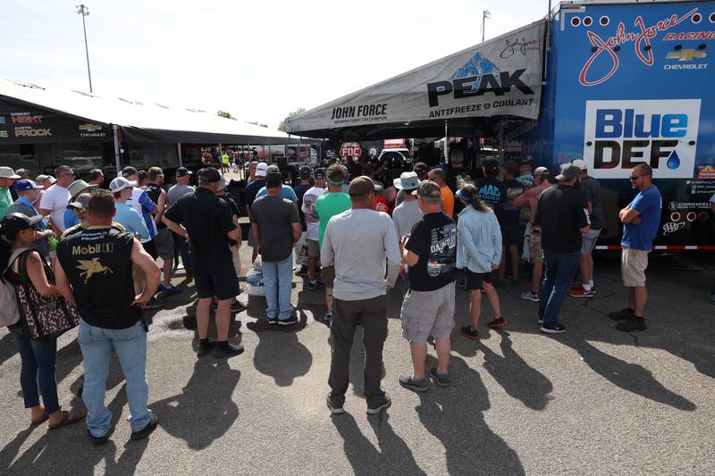 Race fans crowd around John Force’s trailer as crew work on the car before the Funny Car championship race at the NHRA’s Gerber Collision and Glass Route 66 Nationals at Route 66 Raceway on Sunday, May 19, 2024 in Joliet.