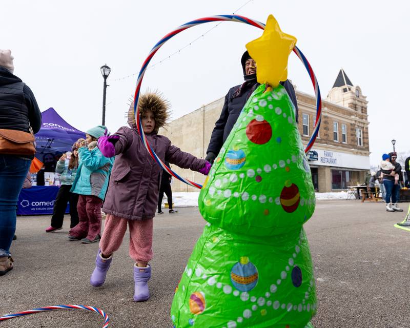 Madeline Prescott throws hula-hoop onto Christmas Tree on Saturday, December 6, 2025 on Illinois Avenue in Mendota.